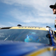 A photo of Nascar driver Chase Elliott sitting on the window of his car.
